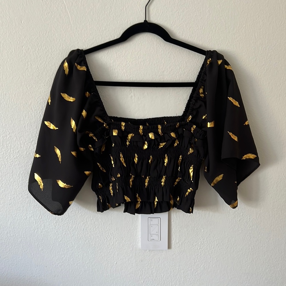 Black and gold fitted smocked house with flowy sleeves